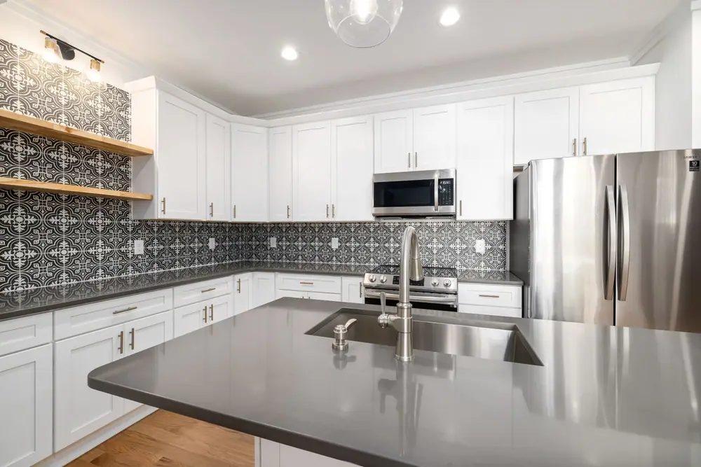 Patterned tile backsplash over grey tops