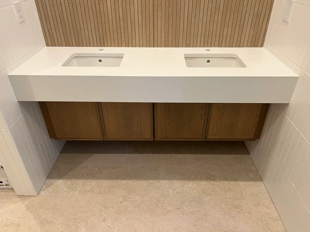 Floating double vanity with a thick white top and two undermount sinks