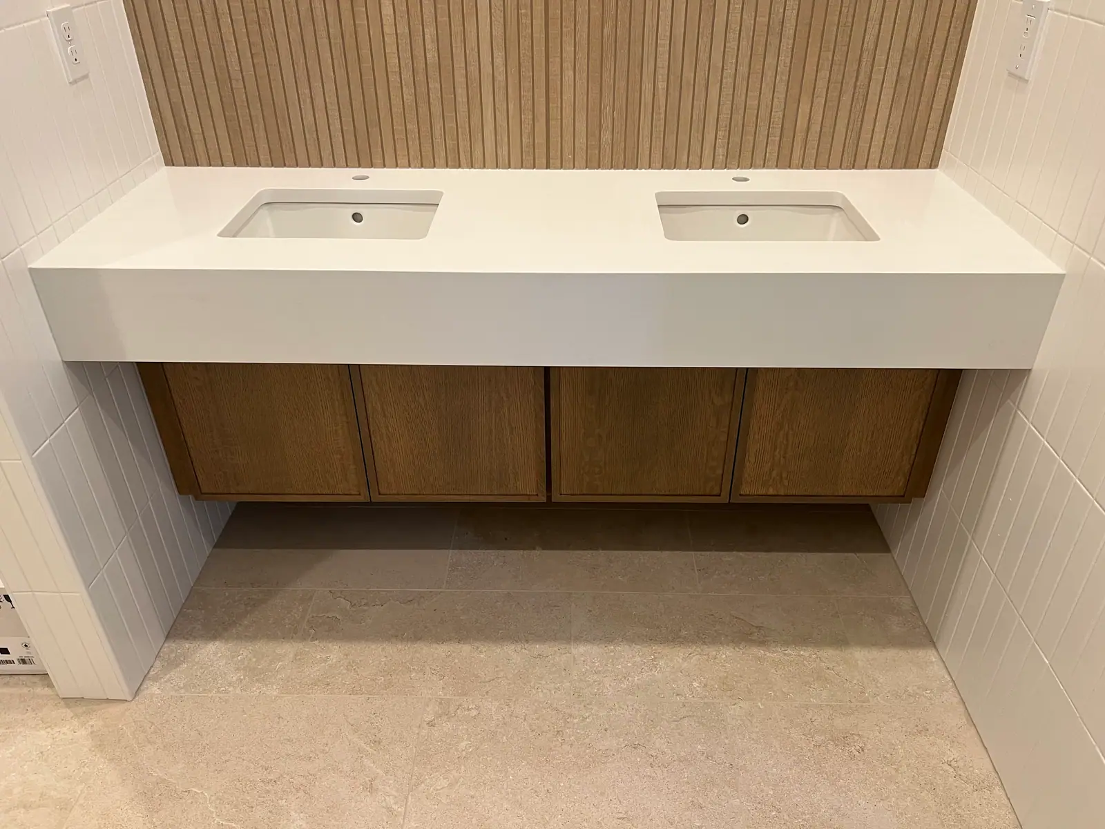 Floating double vanity with a thick white top and two undermount sinks